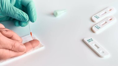 Covid-19 hastalığına neden olan Corona virüsü SARS-CoV-2 'nin özel antikorlarının tespiti için yapılan hızlı hızlı hızlı COVID19 testi. Sıhhiye ya da doktor hasta parmağından alınan kanı teste uygular.