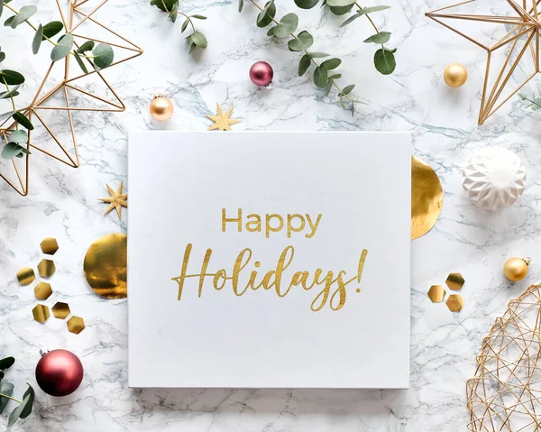 新鮮なユーカリの小枝と黄金の幾何学的な装飾と光のクリスマスのフレーム 六角形 トリンクやワイヤーの形 白い大理石の背景に平らなレイアウトとテキスト Happy Holidays Canvas — ストック写真