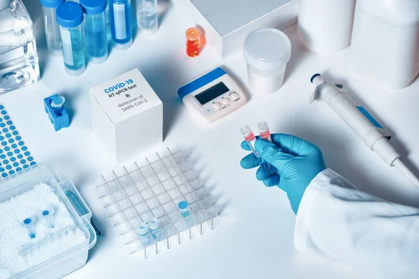 Quick novel COVID-19 coronavirus test kit. 2019 nCoV pcr diagnostics kit. Hand in glove with the box. The kit detects covid19 virus in patients samples. esting system for real-time PCR amplification.