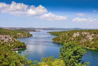 Sibenik Köprüsü 'nden Adriyatik Denizi' ne doğru Krka Nehri 'nin kanyonu manzarası. Hırvatistan 'ın Dalmaçya kentindeki Skradin kasabasının aşağısında. Romantik kıyı şeridi resmi.