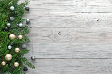 Noel arkaplanı, panoramik üst manzara, sınır dekorasyonlu düz yatış, süslenmiş köknar dalları, beyaz ve gri cam oyuncaklar, yıldızlar, ıvır zıvırlar. Metin ve kopyalama alanı için boşluk.