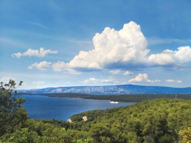 Hırvatistan 'daki Hvar adası. Eski dağ yolundan kuş manzarası. Orman, Adriyatik denizi ve yolcu feribotu.
