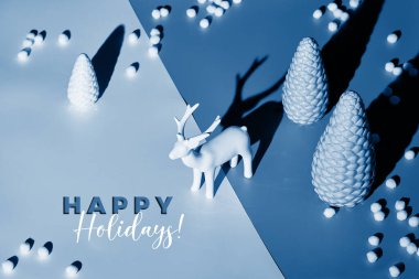 Geyik ve Xmas ağaçlarıyla mavi tonlarda eşölçülü bir Noel düzenlemesi. İki tonluk arka plan kağıdı. Uzun gölge tasarımı. Renk iki ton kağıt arkaplan, metin Mutlu Tatiller