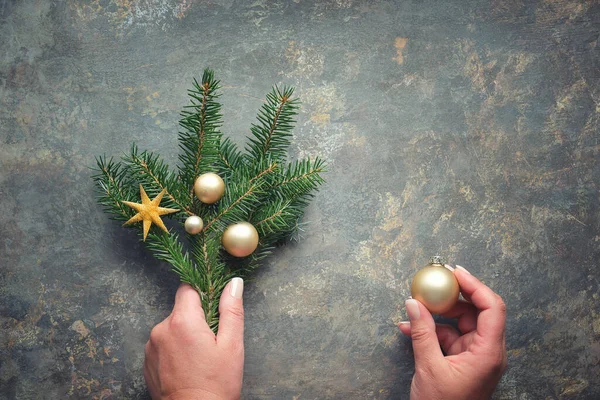 Χριστουγεννιάτικα Στολίδια Επίπεδη Θέσει Χέρια Κρατώντας Κλαδιά Έλατο Διακοσμημένα Χρυσά — Φωτογραφία Αρχείου