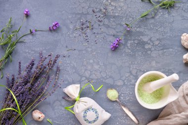 El yapımı lavanta kesesi ve ev yapımı banyo tuzu. Taze ve kuru lavanta çiçekleri. Gri desenli masada düz yatıyordu.