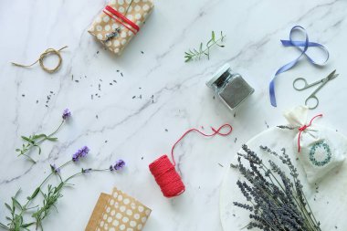 Kendi yaptığım lavanta kesesi ve aromatik bitki karışımı banyo tuzu yapıyorum. Lavanta çiçekleri, taze ve kuru. Düz beyaz mermer üzerinde yatıyordu.