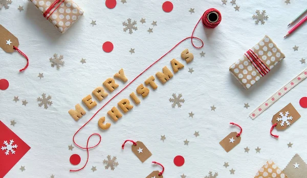 テキストクッキーの手紙で作られたメリークリスマス ギフトボックスとクラフト紙で作られた装飾が施された創造的なクリスマスフラットレイアウト 幾何学的な配置 ゼロ廃棄物環境に優しいお祝いの装飾 — ストック写真