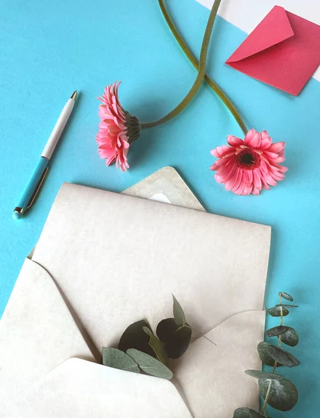 ピンクの花は白い封筒の上に優雅に置かれ 対照的で目を引くイメージを作成します グリーティングカードのコピースペース — ストック写真