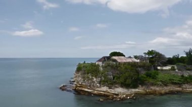 İnsansız hava aracı James Kalesi harabeleriyle hızla adanın etrafında uçarken ufukta St. Johns, Antigua ve Barbuda 'da bir yolcu gemisi görünüyor. 