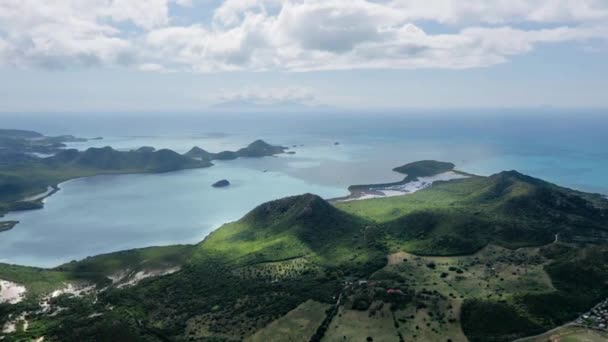 Drone schiet groene heuvels op het eiland in de azuurblauwe zee op een zonnige dag Vijf eilanden, Antigua en Barbuda — Stockvideo
