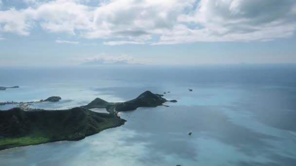 Blick aus der Vogelperspektive auf das azurblaue Meer und eine grüne Insel mit Bergen Fünf Inseln, Antigua und Barbuda — Stockvideo