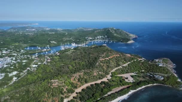 Drone vue une colline de l'île avec une ville et la baie avec des yachts blancs Antigua-et-Barbuda — Video