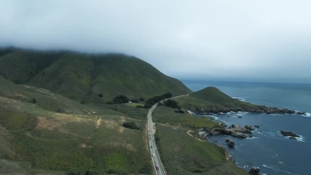 Imágenes aéreas, los coches conducen a lo largo de la carretera por el océano, la cima de la montaña en la niebla en Garrapata, California, EE.UU. — Vídeo de stock