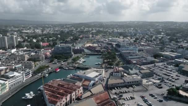 Zdjęcia lotnicze nad miastem, rzeka z białym jachtem i mosty z samochodami w Bridgetown, Barbados — Wideo stockowe
