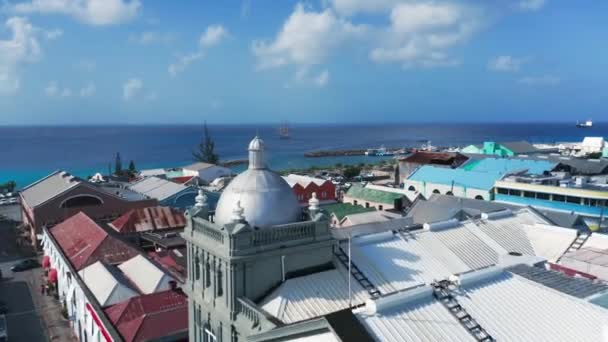 Drone närmar sig ett fartyg till sjöss genom staden över tak, bilar, människor, hamnen i Bridgetown, Barbados — Stockvideo