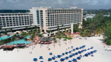 İnsansız hava aracı otelden, tropikal bitki örtüsünden Bridgetown, Barbados 'taki beyaz kumlu plajdan uzaklaşıyor.