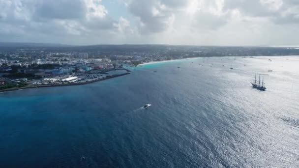 Вид с высоты птичьего полета на яхту, плывущую по морю недалеко от Бриджтауна, Барбадос, есть много других яхт и корабль поблизости — стоковое видео