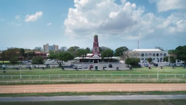 バルバドスのブリッジタウンにあるガリソン・サバンナ競馬場の赤いチャペルから後退するドローンカメラ — ストック動画