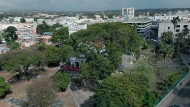 Imágenes aéreas de la Iglesia de San Miguel escondida detrás de los árboles en Bridgetown, Barbados — Vídeos de Stock
