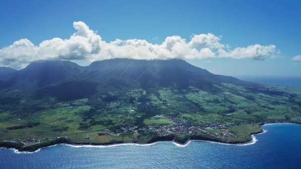 Légi felvétel a Liamiuga hegyről egy zöld szigeten trópusi erdőkkel és kisvárossal Saint Kitts és Nevis-ben — Stock videók