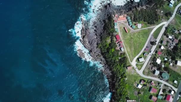 Drohnenaufnahmen von azurblauem Meer, schwarzer Küste und Dächern an der Küste in St. Kitts und Nevis — Stockvideo