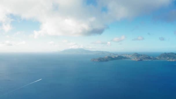 Drohnen-Kamerafahrt von zwei Yachten auf dem Weg zu einer hügeligen Insel in St. Kitts und Nevis — Stockvideo