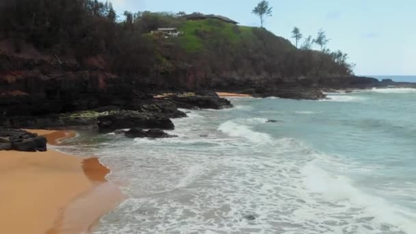 Luchtfoto drone camera schiet oceaangolven, een deel van het strand en het huis op de berg bij Kauai, Hawaii, Verenigde Staten — Stockvideo