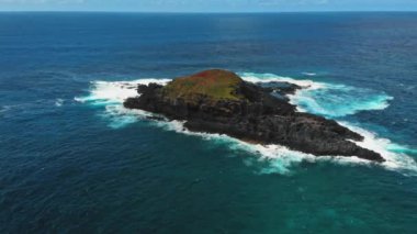 Kauai, Hawaii, ABD 'de bir kaya ve köpük dalgasının hızlandırılmış drone görüntüsü.
