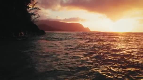 Kauai, Hawaii, ABD 'de gün batımında kayalık bir sahilin yakınındaki dalgaların insansız hava aracı görüntüleri. — Stok video