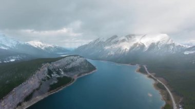 İnsansız hava aracı Kanada Alberta 'daki Sprey Gölleri' nin yakınındaki bulutlarda karlı tepeler gösteriyor.