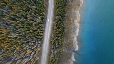 Kuş gözü videosu Sprey Göller Barajı 'nın kıyılarını ve Kanada Alberta yakınlarındaki bir orman yolunu gösteriyor.