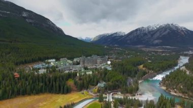 Bow River (Banff, Alberta, Kanada) yakınlarındaki dağların eteklerindeki büyük otelin hava görüntüleri)