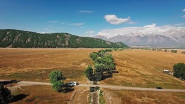 Hava görüntüleri, Wyoming, Mormon Row, ABD 'deki Golden Prairie' den geçen bir karavanı gösteriyor.