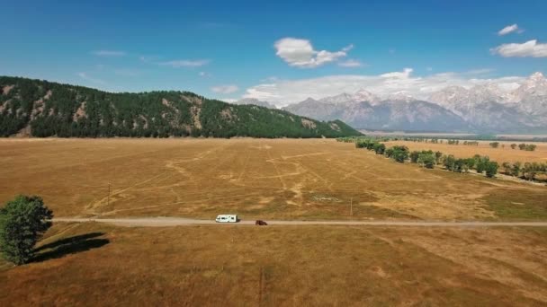 Luchtfoto van zware bergen, helderblauwe luchten en eindeloze prairies bij Mormon Row, Wyoming, USA — Stockvideo