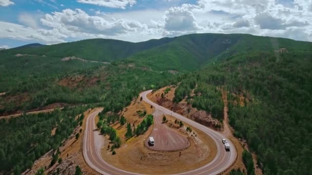 Дрон знімає звивисту дорогу на схилі гори, яка пролягає густим лісом у Вайомінгу (США). — стокове відео