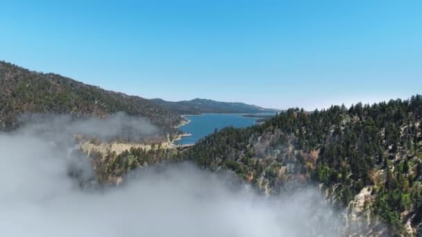 Dron letí přes kopce v mlze směrem k Big Bear Lake, Kalifornie, USA — Stock video