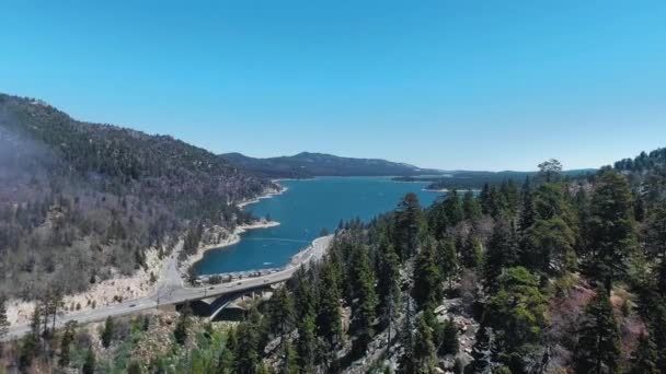 O drone voa sobre a estrada que vai ao longo da costa de Big Bear Lake, Califórnia, EUA — Vídeo de Stock