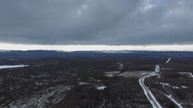 Kanada Alberta 'da bulutlu bir kış gününde sık bir ormanın kuş bakışı manzarası ve Evie Gölü