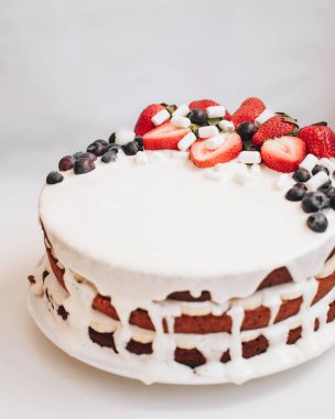 Beyaz krema, çilek ve yaban mersini ile bir pasta