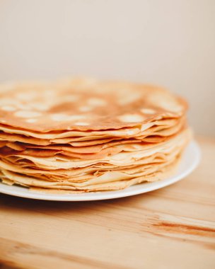 Tahta bir masanın üzerinde bir yığın krep.