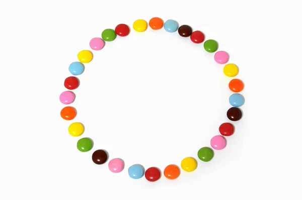 Cerchio di cioccolato colorato sparso su sfondo bianco — Foto Stock