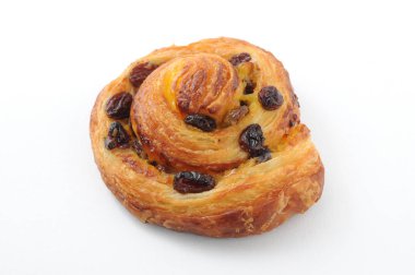 Beyaz arka plan üzerinde izole tarçınlı üzümlü rulo pasta