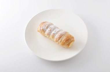 Beyaz arka plan üzerinde tabakta izole krem pasta ile Cannoli kornet