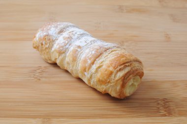 Kesme tahtası üzerinde krem pasta ile Cannoli kornet