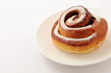 Beyaz arka plan üzerinde izole plaka closeup tarçın rulo 