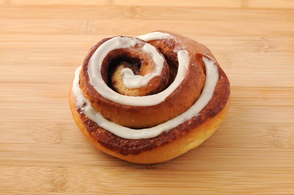 Cinnamon roll isolated on cutting board — Stock Photo, Image