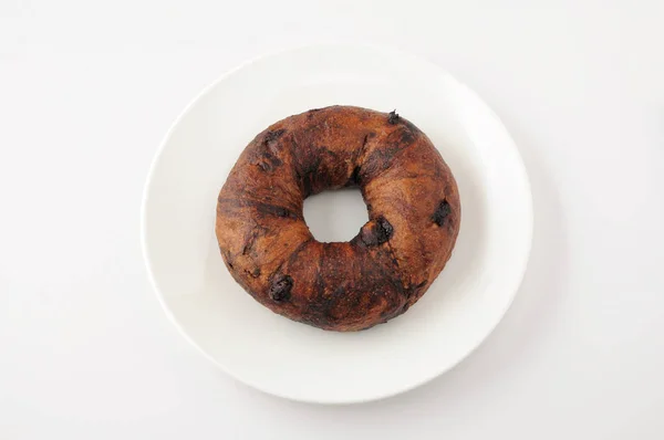 Chocolate chip bagel bread isolated on plate on white background — Stock Photo, Image