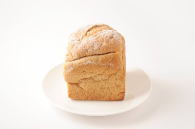 Beyaz arka plan üzerinde izole tabakta kaba bir öğütme çavdar ve buğday unu ekmek