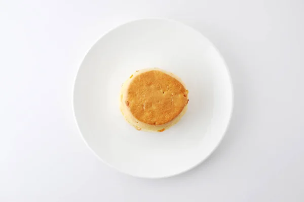 Biscoito de scone simples isolado em uma placa no fundo branco — Fotografia de Stock