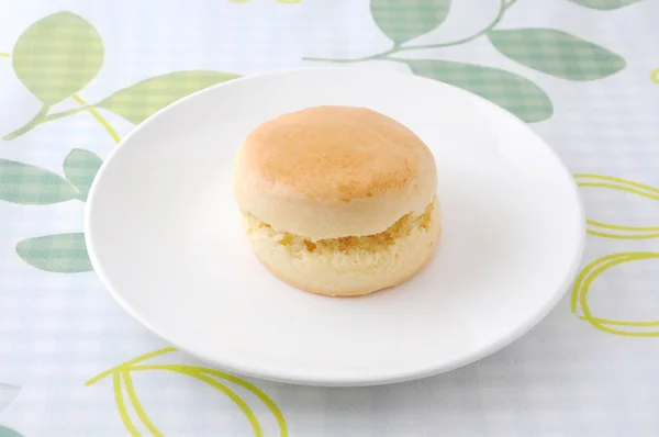 Einfacher Scone-Keks auf einem Teller auf Tischdecke — Stockfoto